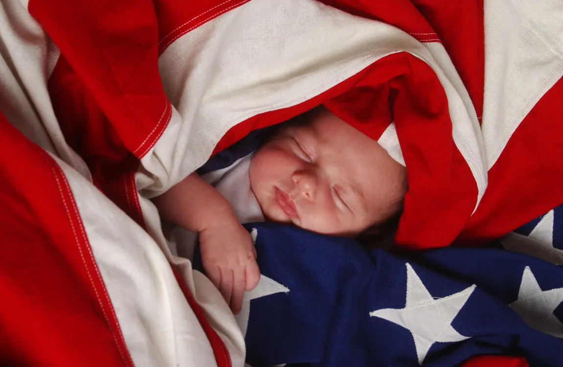 Sleeping newborn wrapped in an American flag