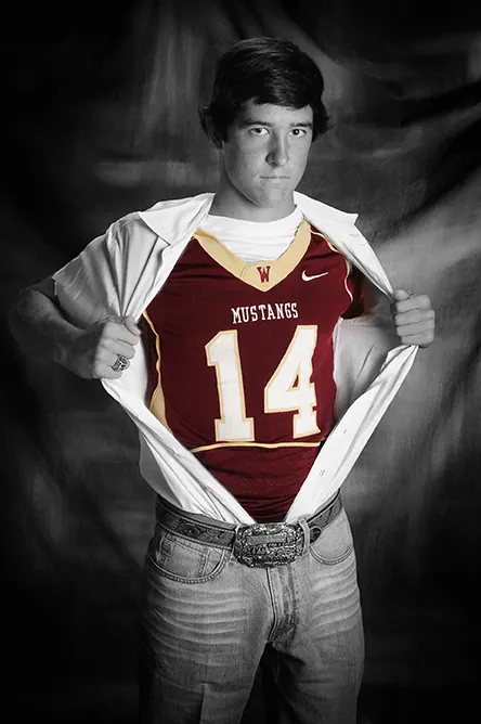 Black-and-white Superman-style senior portrait revealing a Mustangs number 14 football jersey