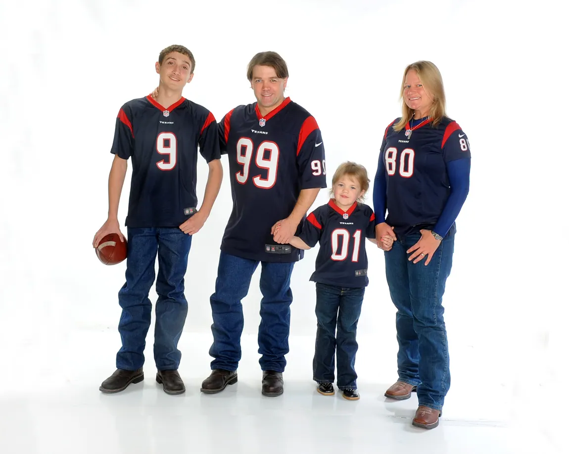 Family in Houston Texans jerseys with a football on a white background