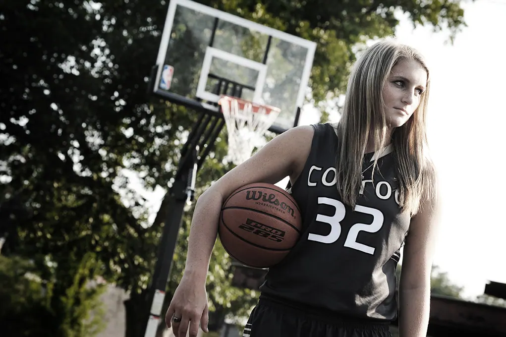 Basketball senior in a Conroe number 32 jersey holding a ball under the hoop