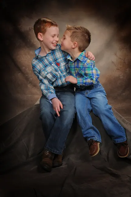 Two young brothers in plaid shirts sharing a laugh