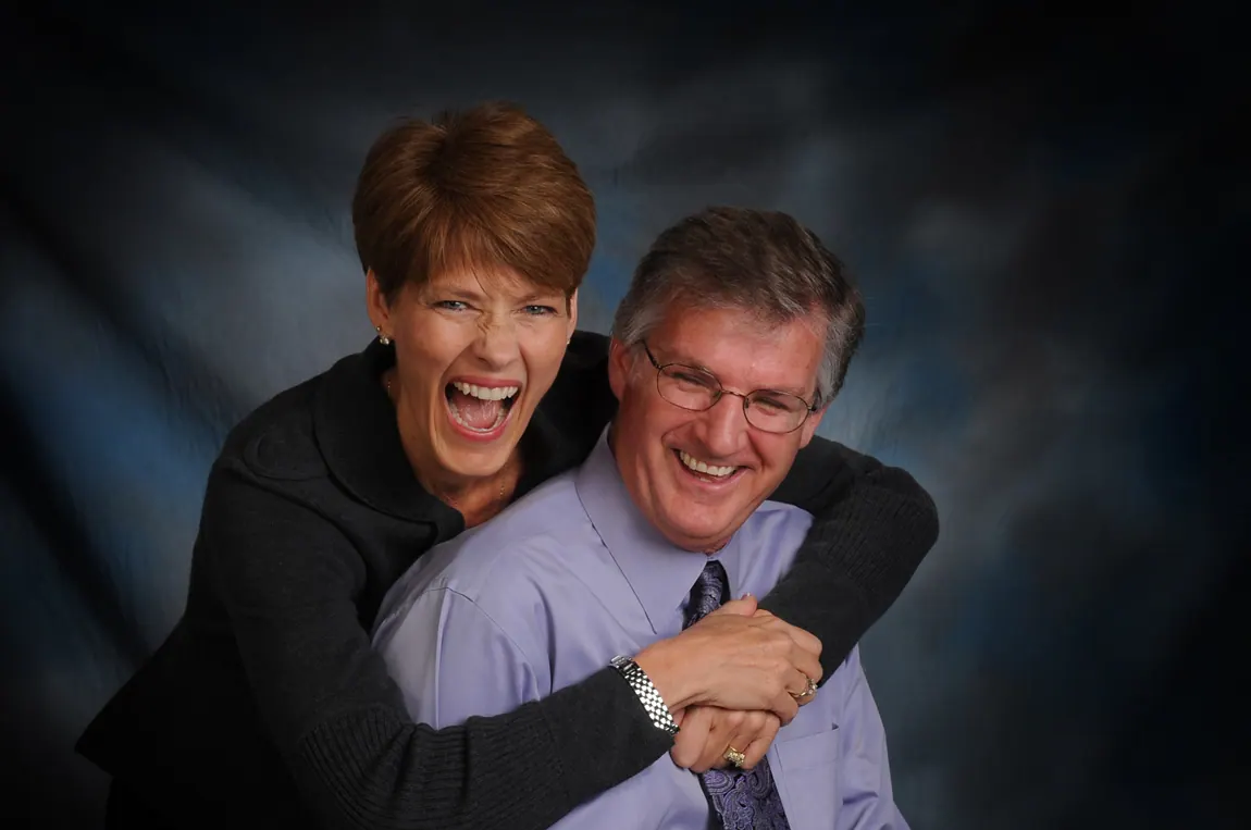 Laughing couple hugging in a studio portrait