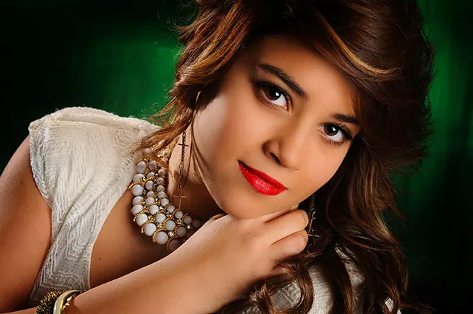 Glamour studio portrait of a senior girl with red lips and pearls