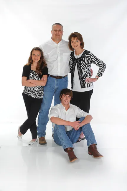 Family of four in black and white outfits on a white studio background