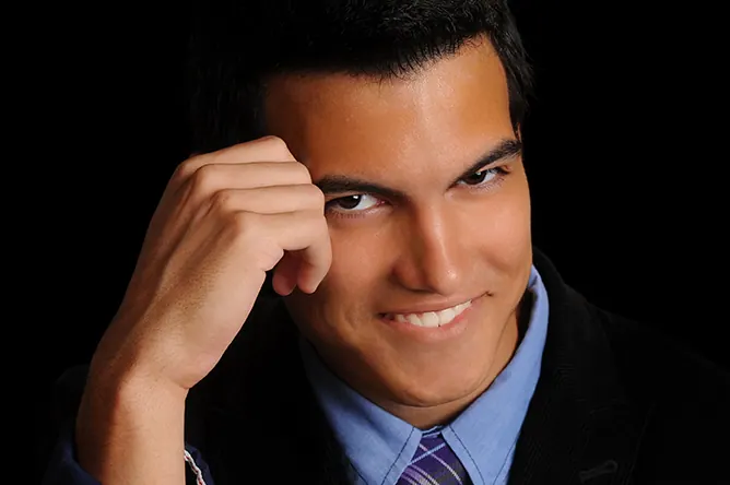 Classic studio headshot of a smiling senior in a suit and tie